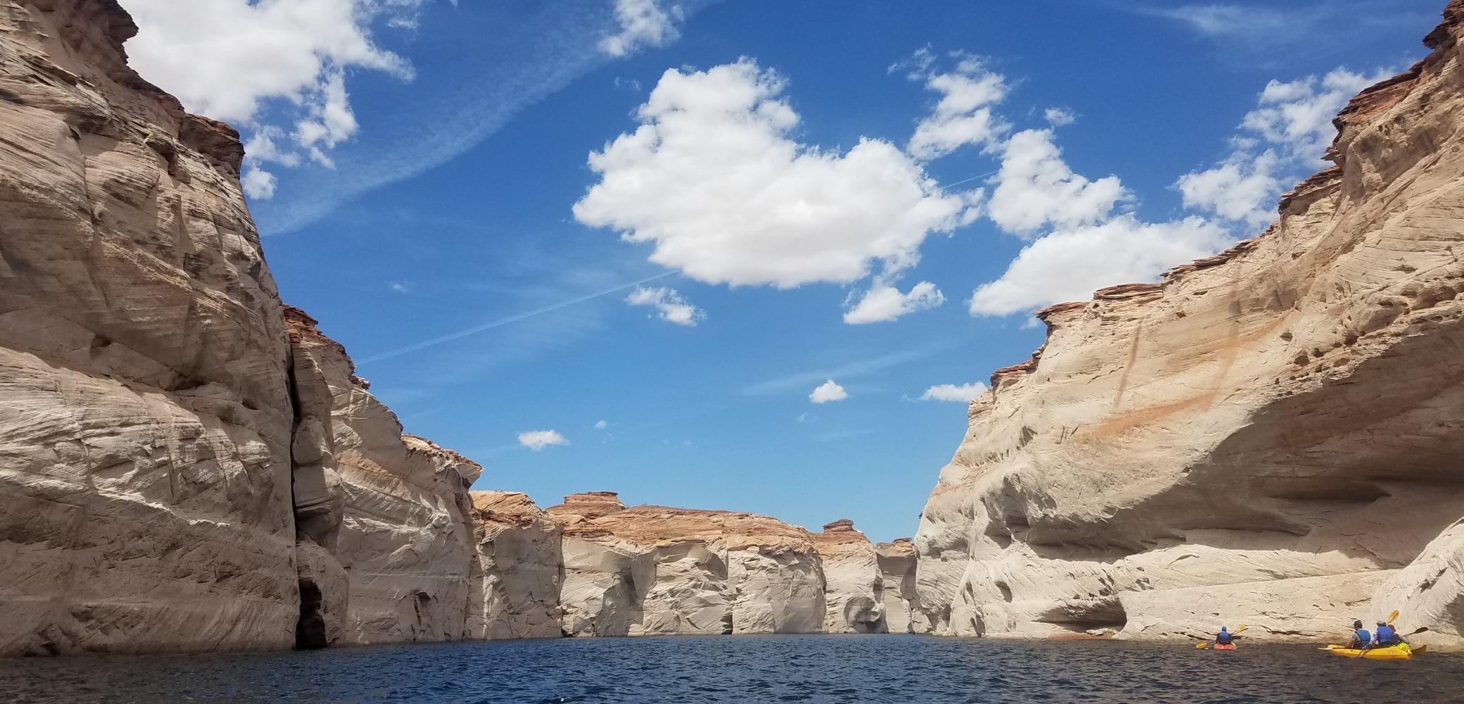 3 kayakers paddling into a canyon on lake powell on a guided tour