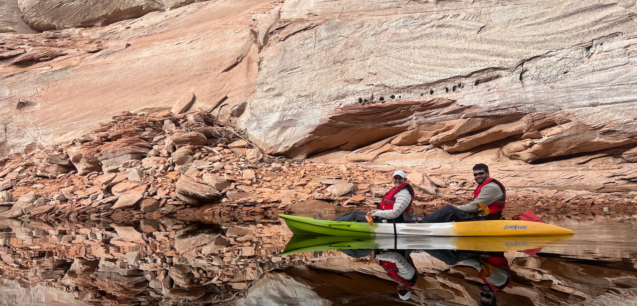two people in a double kayak paddling up lake powell to antelop canyon