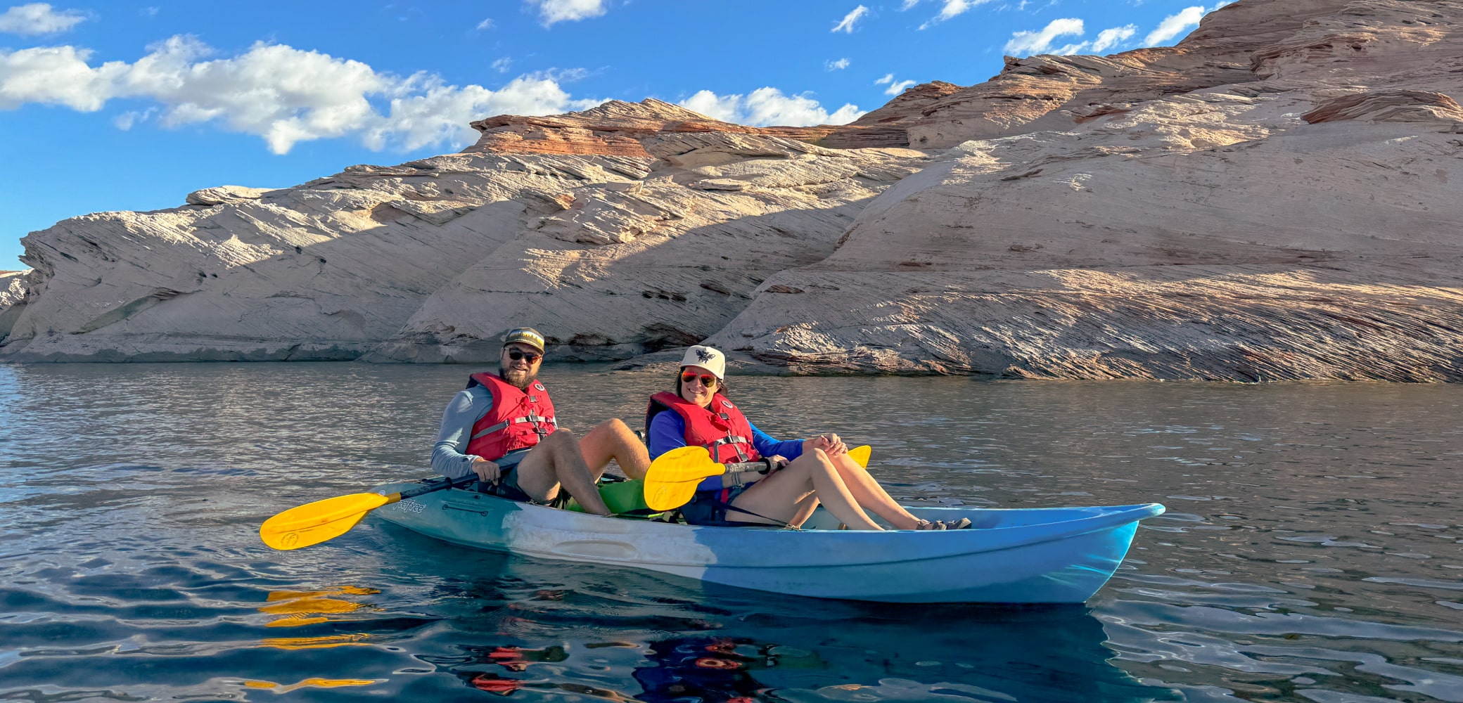 two people in a double kayak paddling on lake powell on a private tour