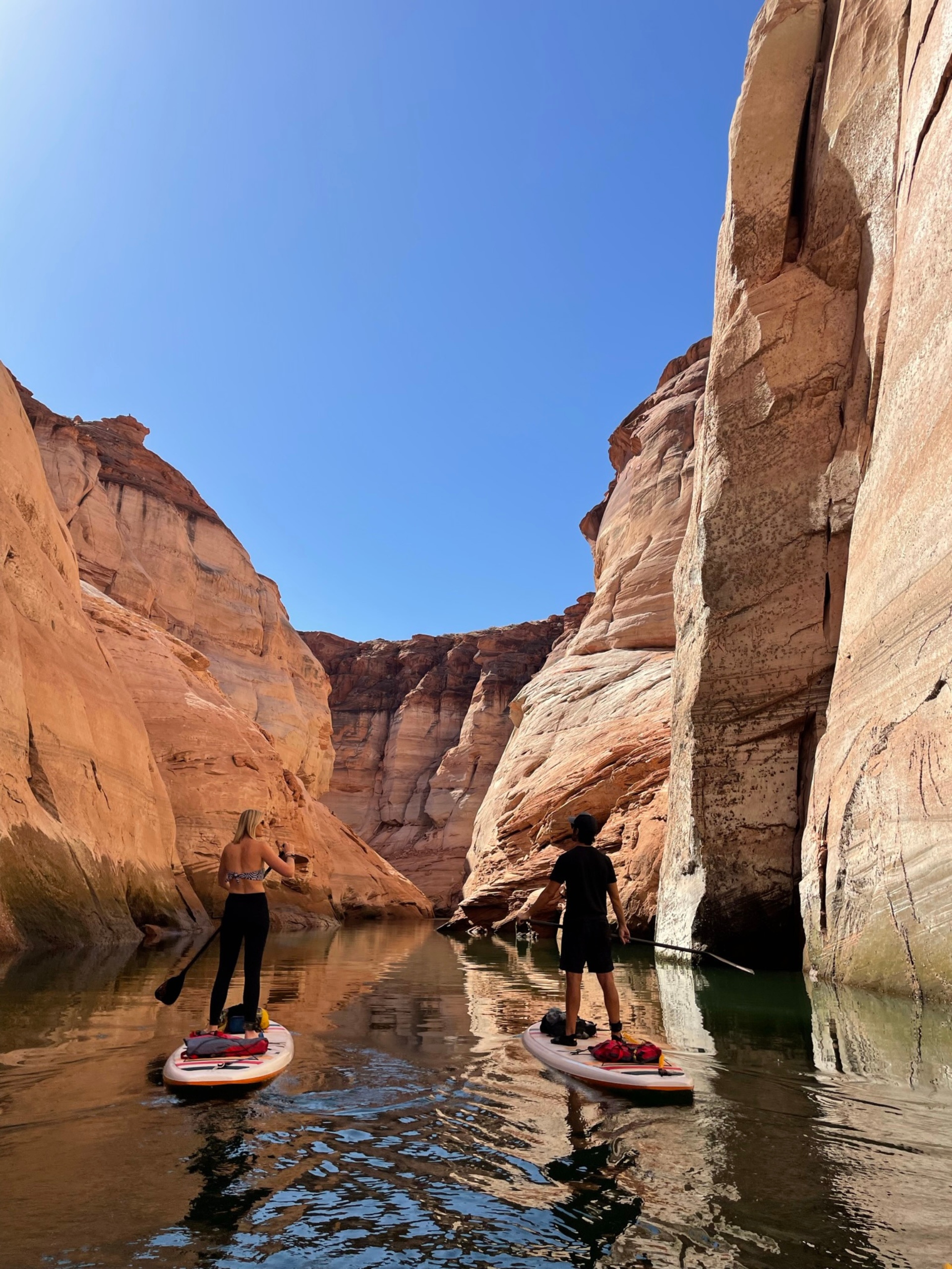 Two people paddle through Antelope Canyon on paddleboards